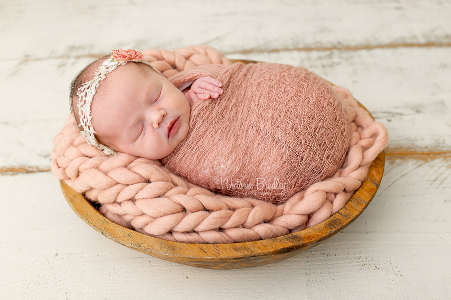 photo of baby in a wooden bowl with dusky pink wrap